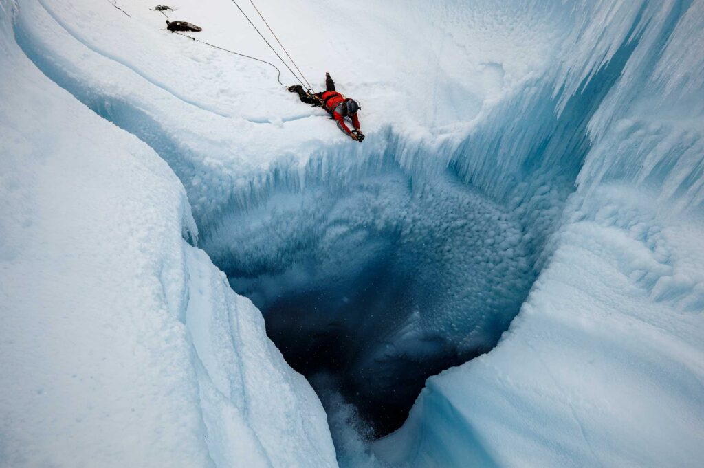 Extreme Ice Survey Founder and Director James Balog photographs waterfall dropping into crevasse in Survey Canyon, Survey Canyon, Greenland (2009)